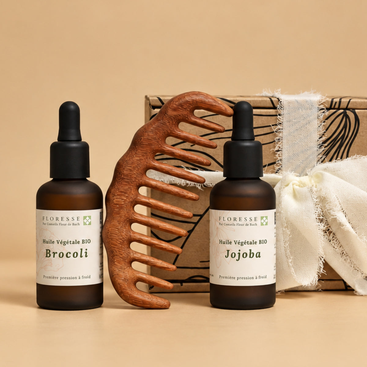Coffret soin capillaire naturel comprenant l'huile de brocoli, l'huile de jojoba et un peigne en bois.
