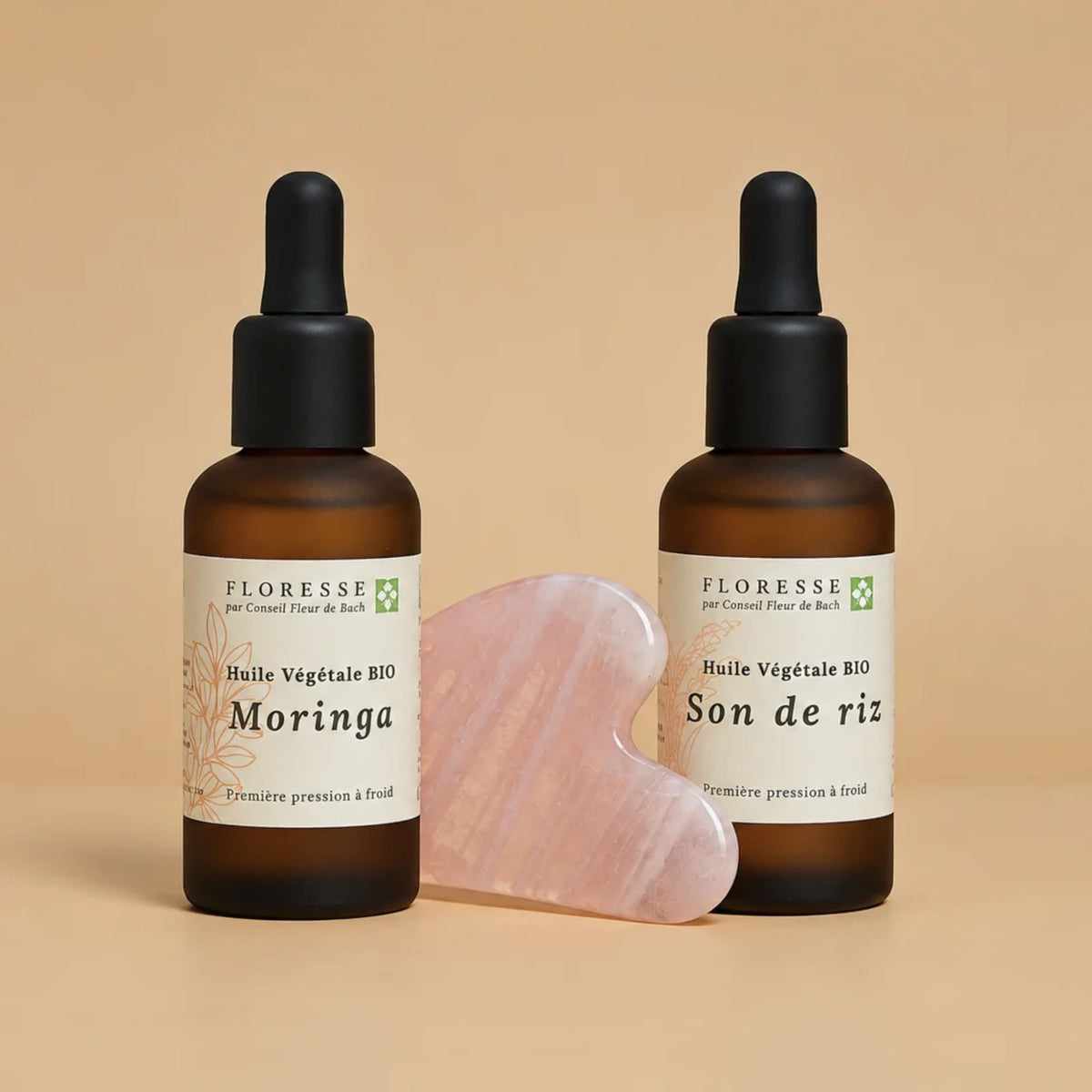 Outil de massage Gua Sha accompagné de son duo d'huiles végétales pour le visage.