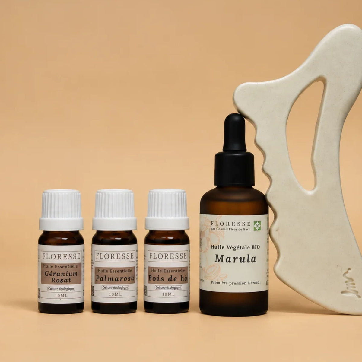 Huile végétale, trois huiles essentielles et Gua Sha en céramique pour le massage du corps.