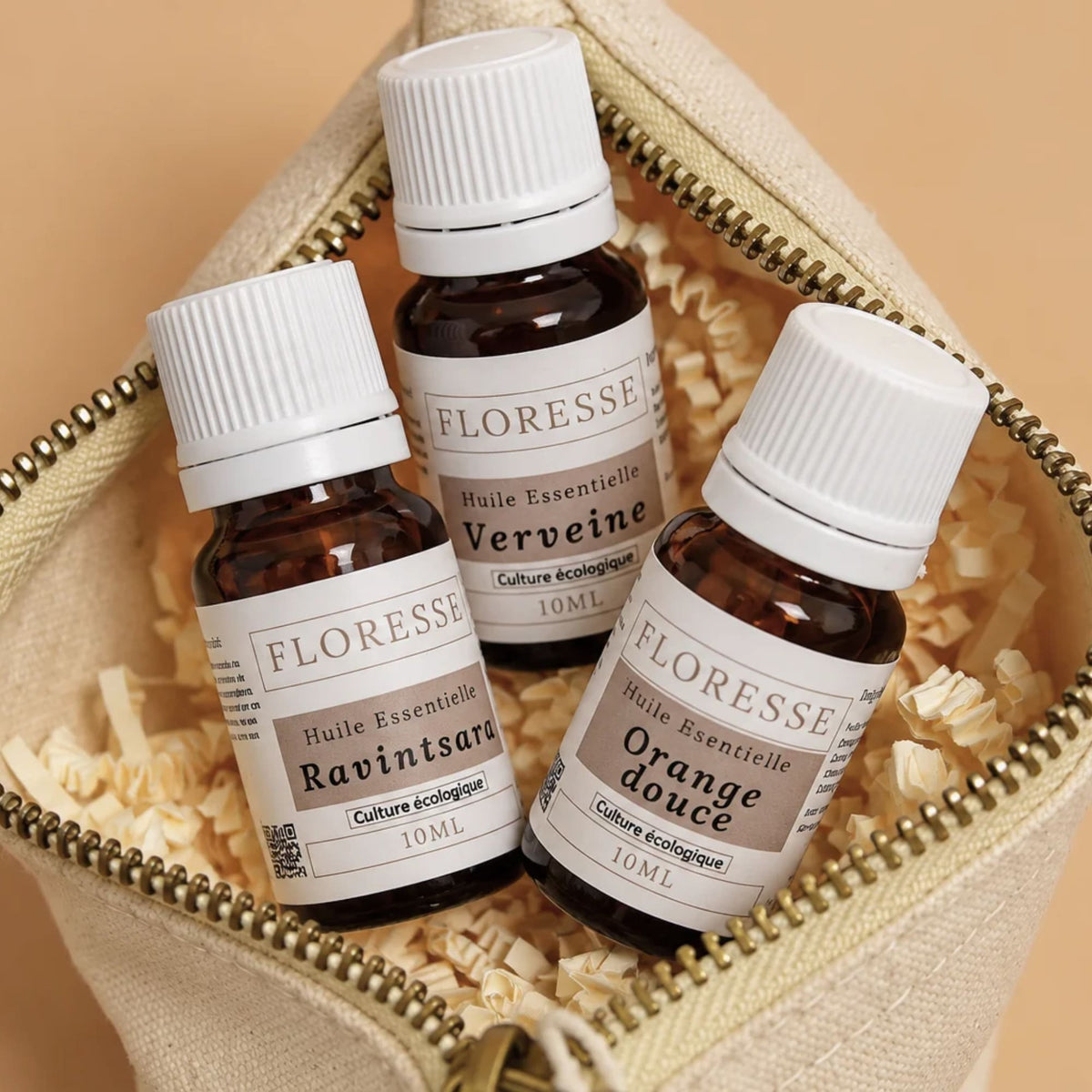 Trio d'huiles essentielles pures rangées dans leur trousse en tissu.