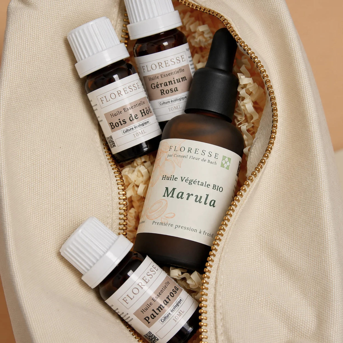 Huile végétale, huiles essentielles et Gua Sha céramique corps rangés dans leur trousse.