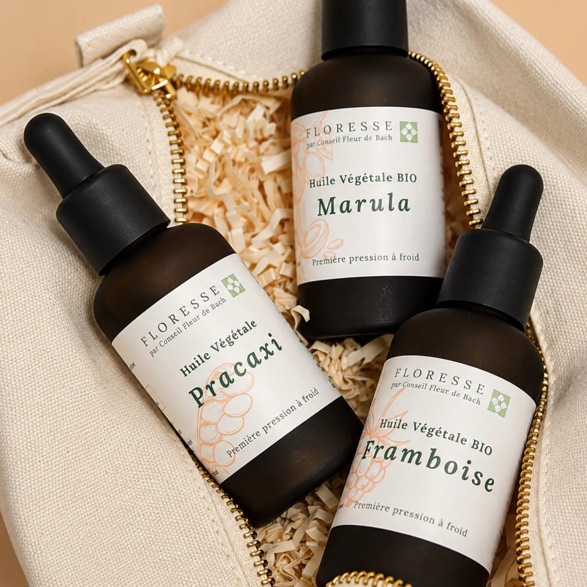 Trio d'huiles végétales présentées avec leur trousse de rangement.